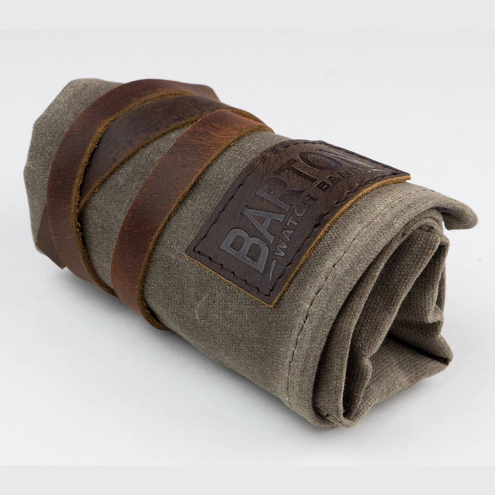Waxed canvas watch roll rolled up and tied with a brown leather strap