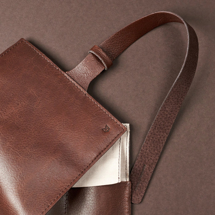 Close-up of brown leather watch roll wrap strap and stitched flap